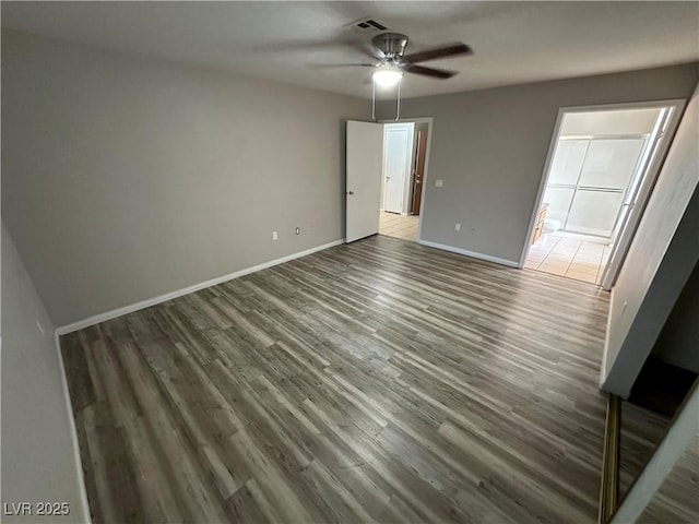 unfurnished bedroom with dark wood-style floors, baseboards, and a ceiling fan