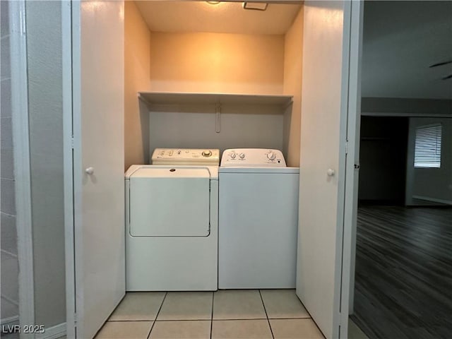 clothes washing area featuring laundry area, light tile patterned flooring, and independent washer and dryer