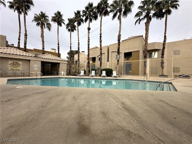 pool with a patio and fence