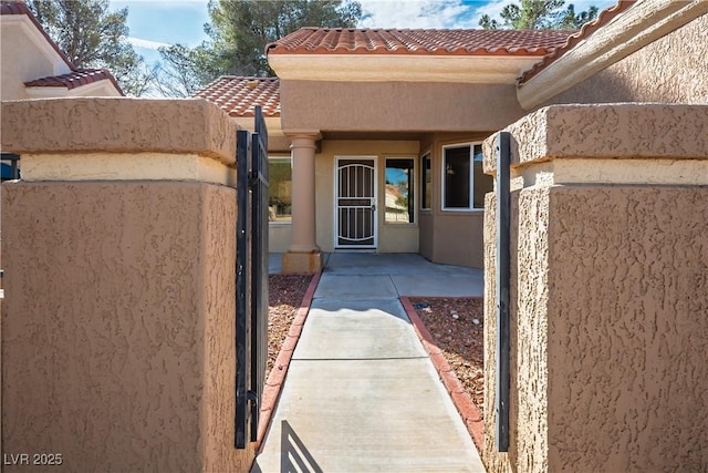 entrance to property featuring stucco siding and a tiled roof