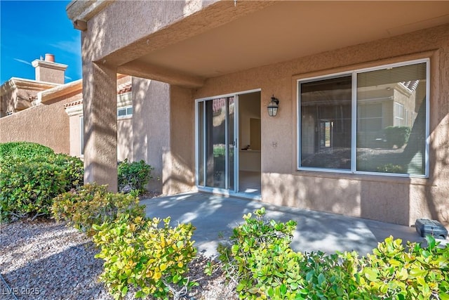 entrance to property with a patio area and stucco siding