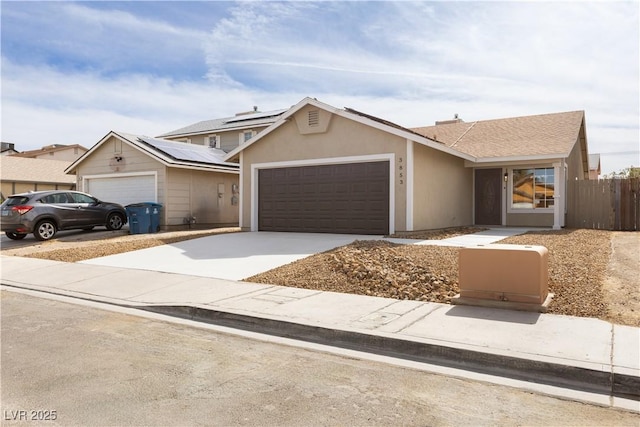 view of front of house with driveway, an attached garage, fence, and stucco siding