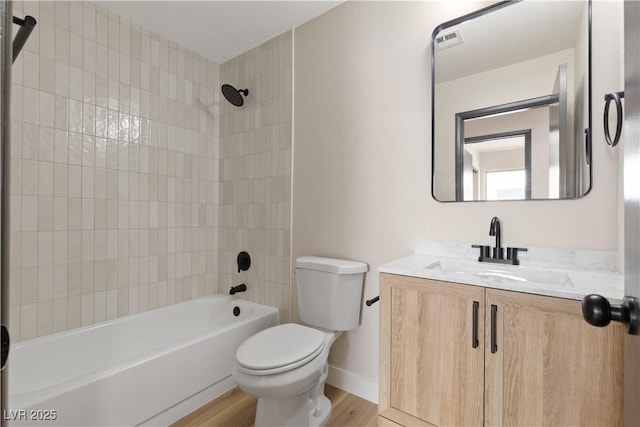 bathroom featuring bathtub / shower combination, toilet, vanity, wood finished floors, and baseboards