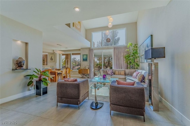 living room featuring a high ceiling and baseboards