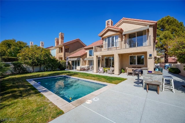 back of house with a fenced in pool, a yard, a patio, a balcony, and a fenced backyard