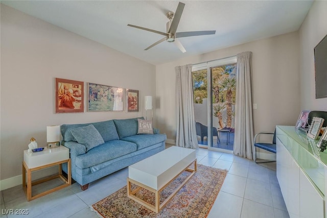 living area with baseboards, a ceiling fan, and light tile patterned flooring