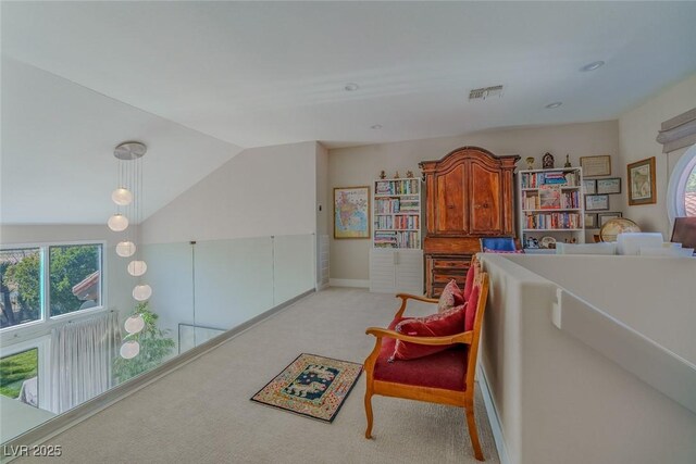 living area featuring lofted ceiling, light carpet, and visible vents