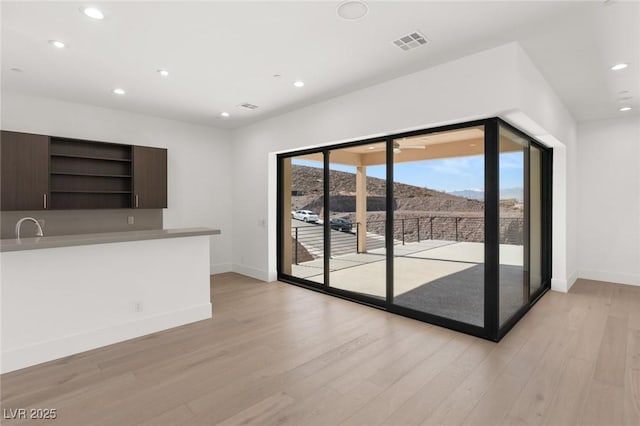 unfurnished living room with light wood-style floors, recessed lighting, visible vents, and a mountain view