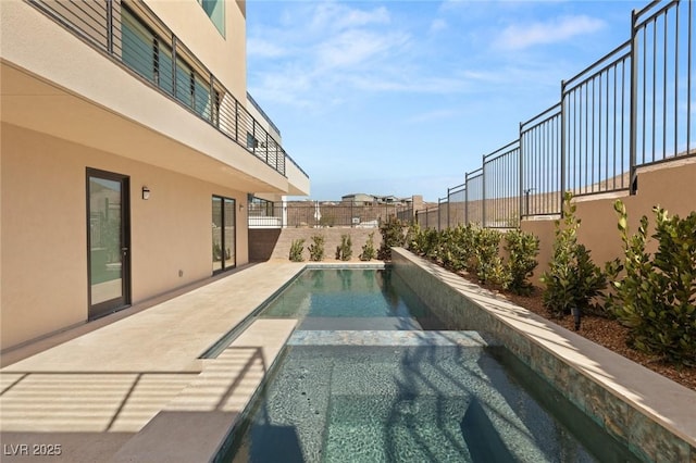 view of swimming pool with fence and an in ground hot tub