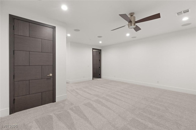 spare room with recessed lighting, visible vents, light carpet, and baseboards