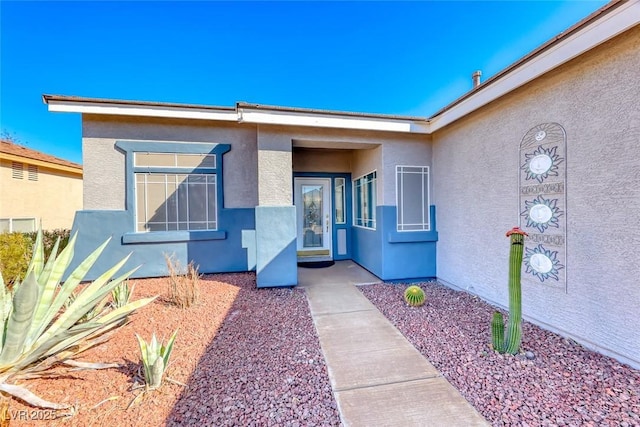 doorway to property featuring stucco siding