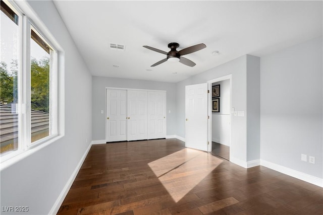 unfurnished bedroom with dark wood finished floors, visible vents, and baseboards