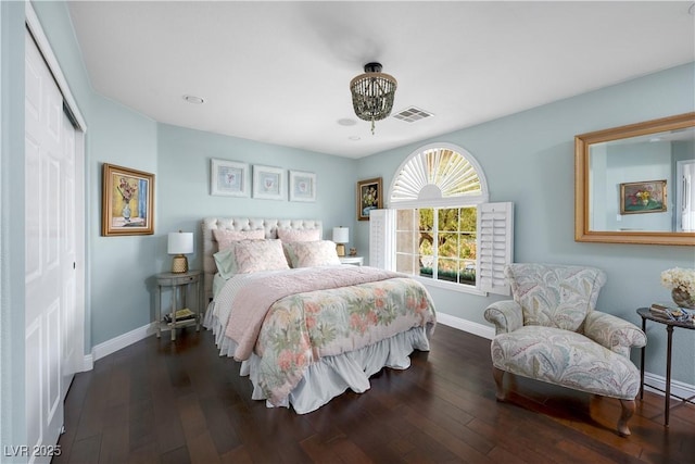 bedroom featuring dark wood-style flooring, a closet, visible vents, and baseboards