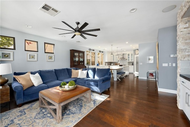 living room featuring dark wood-type flooring, recessed lighting, visible vents, and baseboards