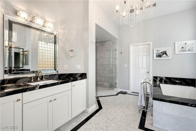 bathroom featuring a freestanding bath, an inviting chandelier, a stall shower, vanity, and tile patterned flooring