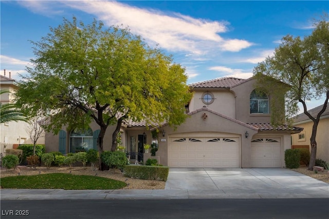 mediterranean / spanish home with concrete driveway, a tiled roof, and stucco siding