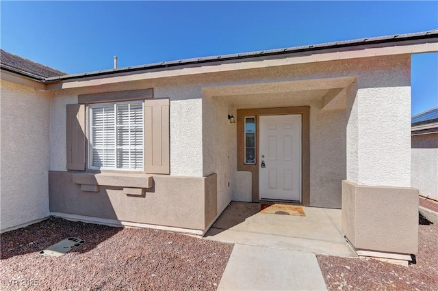 doorway to property with a patio area and stucco siding