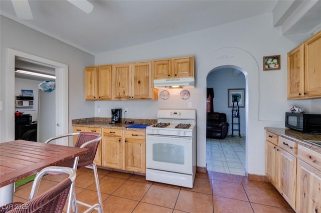 kitchen featuring dark countertops, white gas range, under cabinet range hood, light brown cabinets, and black microwave