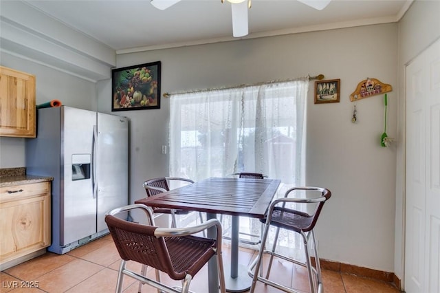 dining space featuring ornamental molding, ceiling fan, baseboards, and light tile patterned floors