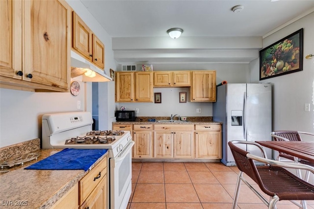 kitchen featuring stainless steel fridge, white gas range, light brown cabinetry, black microwave, and light tile patterned flooring