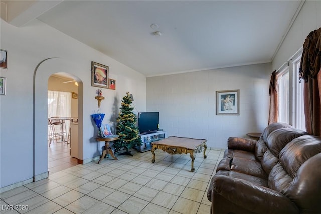 living room featuring arched walkways and light tile patterned floors