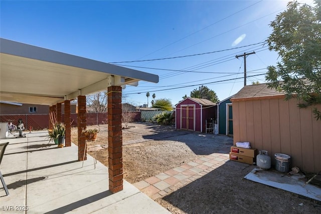 view of patio featuring a storage shed, an outdoor structure, and a fenced backyard