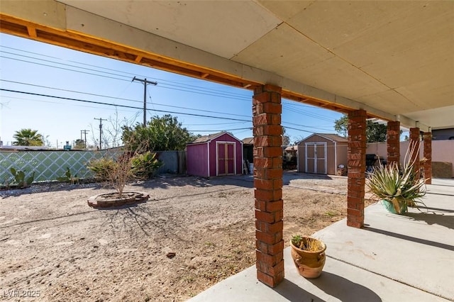 view of yard with a patio area, a fenced backyard, an outdoor structure, and a storage unit