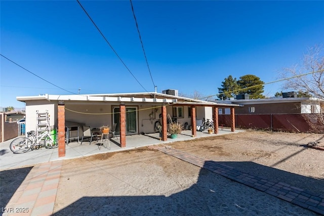 back of property featuring stucco siding, fence, and a patio