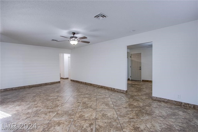 unfurnished room featuring a ceiling fan, baseboards, visible vents, and a textured ceiling