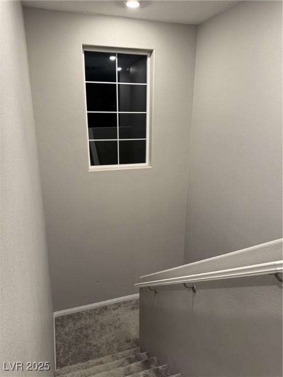 staircase featuring carpet floors and baseboards