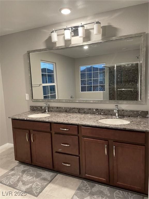 full bathroom featuring double vanity, a stall shower, and a sink