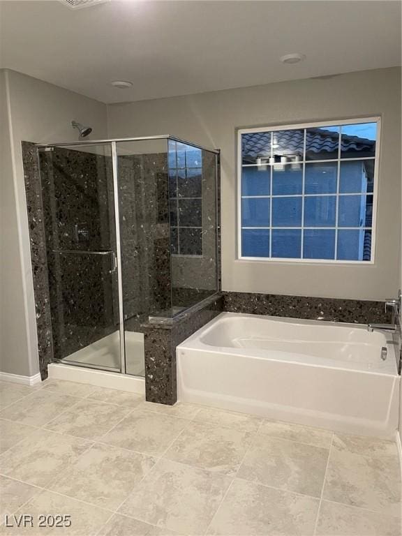 bathroom featuring a stall shower and a garden tub