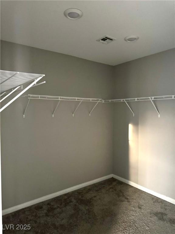 walk in closet with dark carpet and visible vents