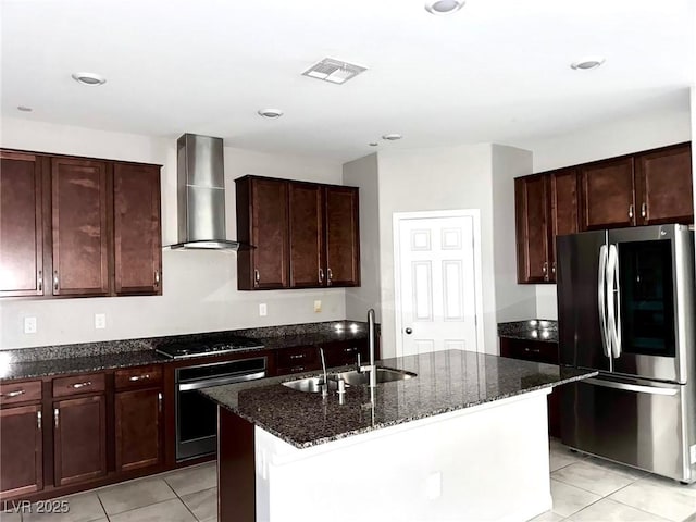 kitchen with wall chimney exhaust hood, stainless steel appliances, a sink, visible vents, and light tile patterned floors