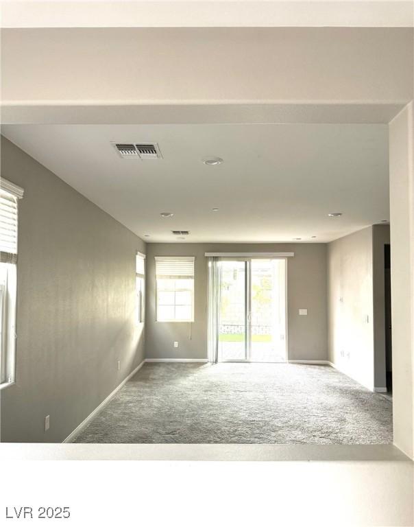 carpeted spare room with baseboards and visible vents
