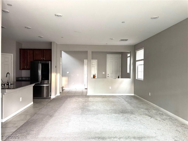 unfurnished living room with visible vents, baseboards, a sink, and recessed lighting