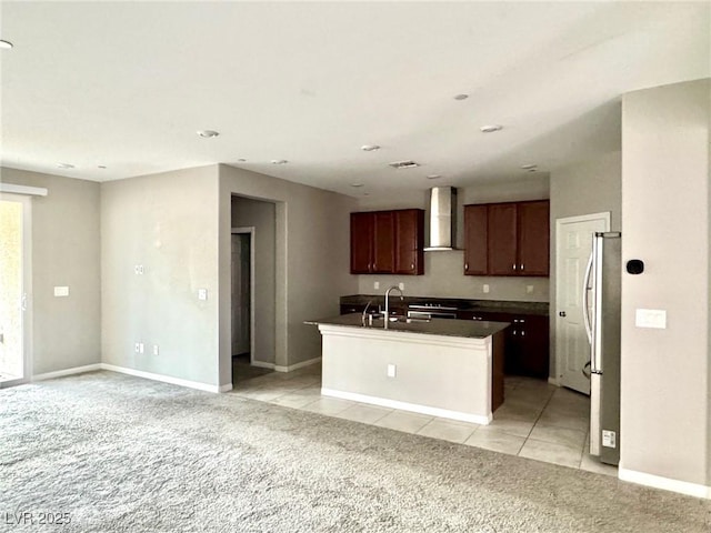 kitchen featuring dark countertops, wall chimney exhaust hood, light colored carpet, and a sink