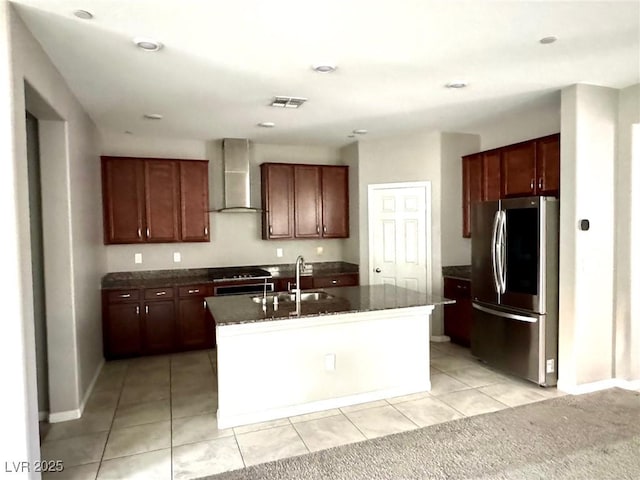 kitchen featuring smart refrigerator, wall chimney range hood, a sink, light tile patterned flooring, and baseboards