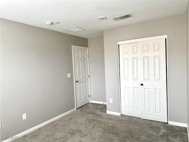 unfurnished bedroom with baseboards, carpet flooring, visible vents, and a closet