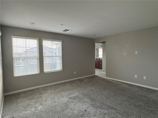 unfurnished room featuring visible vents, baseboards, and carpet