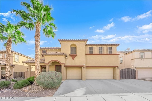 mediterranean / spanish-style home with stucco siding, an attached garage, fence, driveway, and a tiled roof