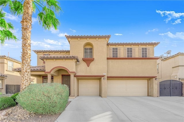 mediterranean / spanish-style house with driveway, a tiled roof, an attached garage, and stucco siding