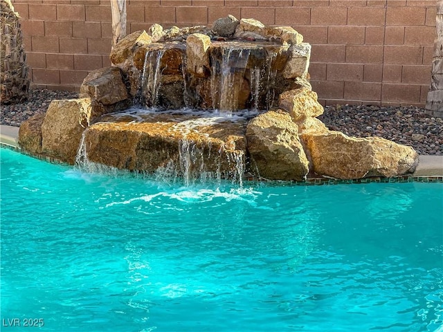 view of swimming pool featuring fence