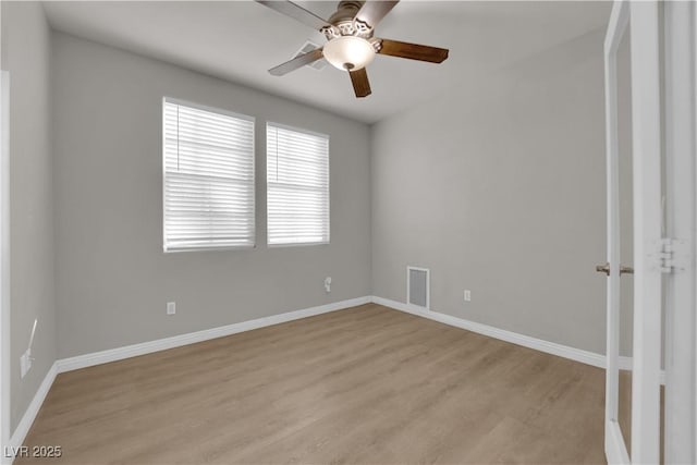 spare room with baseboards, a ceiling fan, visible vents, and light wood-style floors