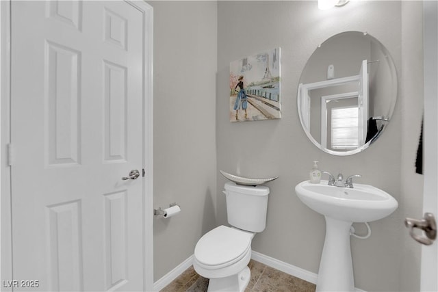 half bathroom featuring toilet, tile patterned flooring, and baseboards