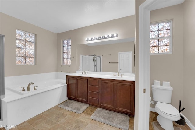 full bathroom with a stall shower, a garden tub, a sink, and toilet