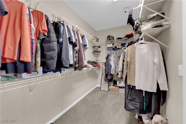 walk in closet featuring visible vents and light colored carpet