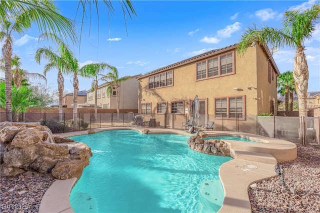 view of swimming pool with a patio area, a pool with connected hot tub, and fence