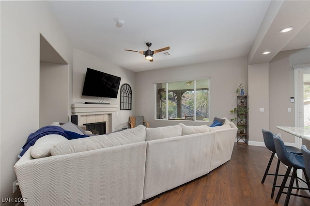 living room with baseboards, a ceiling fan, dark wood-style floors, a fireplace, and recessed lighting