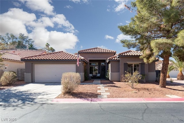 mediterranean / spanish-style home featuring concrete driveway, an attached garage, and stucco siding